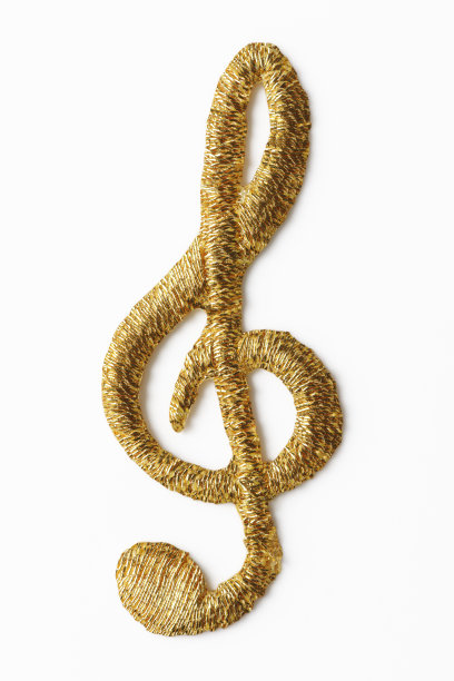 孤立的金色刺绣音符在白色背景上的镜头图片 孤立的金色刺绣音符在白色背景上的镜头图片下载