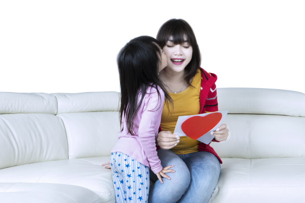 一个女孩在沙发上亲吻她的妈妈图片 一个女孩在沙发上亲吻她的妈妈图片下载