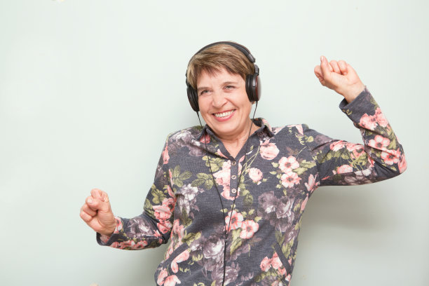 老妇人戴着耳机听音乐和跳舞图片 老妇人戴着耳机听音乐和跳舞图片下载