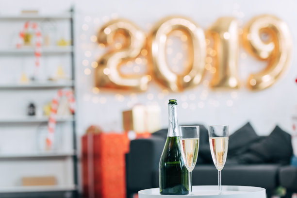 以2019年新年气球为背景的香槟酒瓶和玻璃杯图片 以2019年新年气球为背景的香槟酒瓶和玻璃杯图片下载