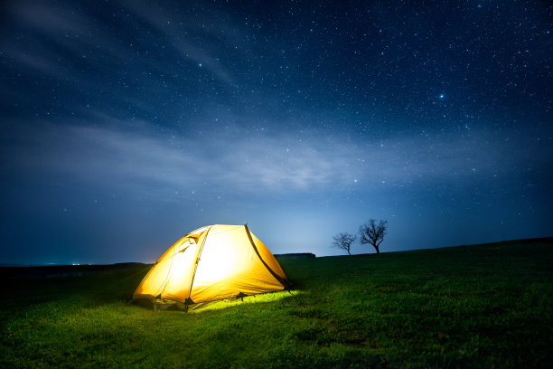 在星空下的夜山中发光的露营帐篷图片 在星空下的夜山中发光的露营帐篷图片下载
