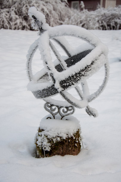 一个冰冻的日晷站在一个满是积雪的花园里图片 一个冰冻的日晷站在一个满是积雪的花园里图片下载