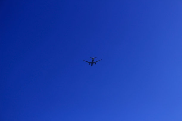 喷气式客机的剪影在晴朗的天空中飞行图片 喷气式客机的剪影在晴朗的天空中飞行图片下载