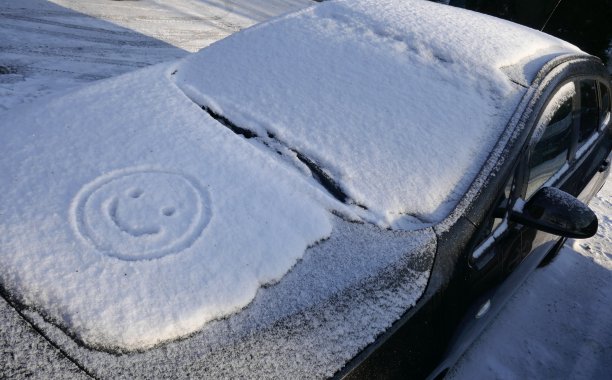 你好冬天!雪,冰和汽车引擎盖上的一张滑稽脸。图片 你好冬天!雪,冰和汽车引擎盖上的一张滑稽脸。图片下载
