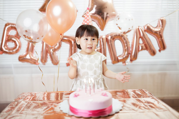 蹒跚学步的小女孩在家里庆祝她的三岁生日图片 蹒跚学步的小女孩在家里庆祝她的三岁生日图片下载