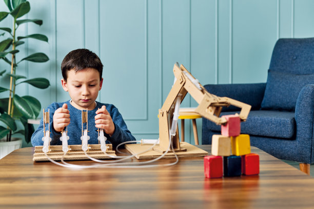 一个6-7岁的孩子发明了一个带纸板和注射器的机械手臂。机器人是他的家庭作业。他在小学时是个成功的学生。图片 一个6-7岁的孩子发明了一个带纸板和注射器的机械手臂。机器人是他的家庭作业。他在小学时是个成功的学生。图片下载