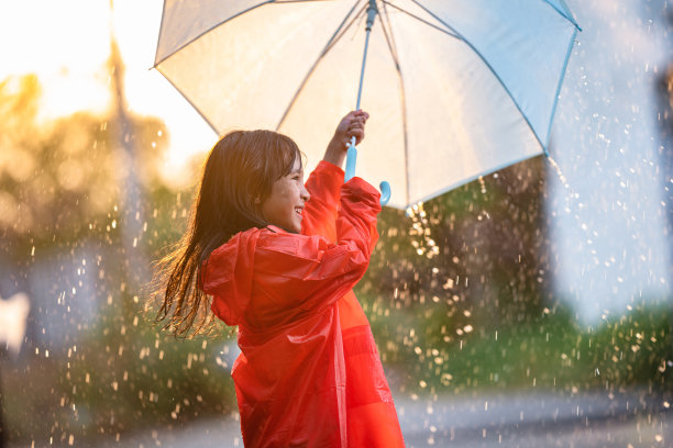 亚洲的孩子们撑着伞在雨中玩耍,她穿着雨衣。图片 亚洲的孩子们撑着伞在雨中玩耍,她穿着雨衣。图片下载