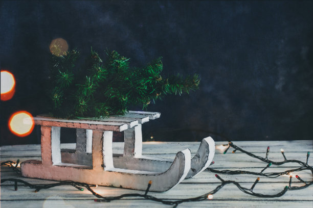 装饰白色雪橇。圣诞树在雪橇上。圣诞节的精神。圣诞组成。灯和散景图片 装饰白色雪橇。圣诞树在雪橇上。圣诞节的精神。圣诞组成。灯和散景图片下载