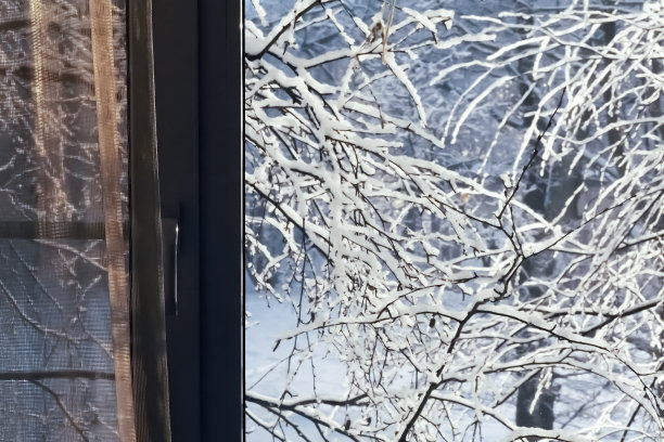 窗外有冬夜景观,白雪覆盖的树木。窗外雪花纷飞。灯笼的光图片 窗外有冬夜景观,白雪覆盖的树木。窗外雪花纷飞。灯笼的光图片下载
