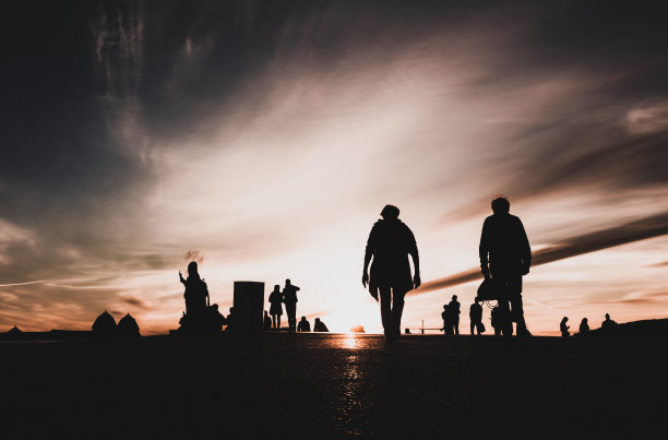 夕阳下屋顶上人们的剪影,背景是天空中的云彩图片 夕阳下屋顶上人们的剪影,背景是天空中的云彩图片下载
