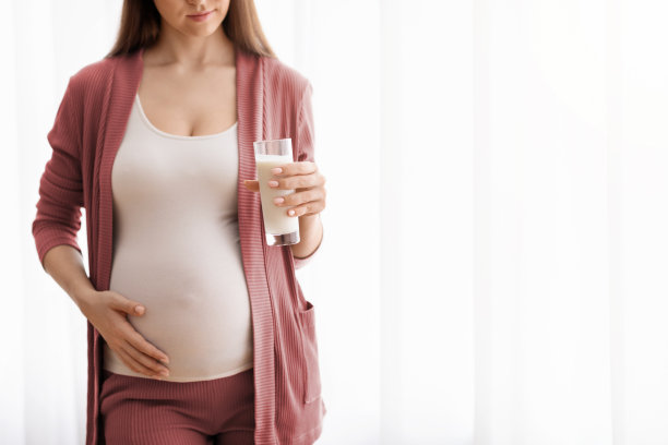 怀孕期间的乳制品。孕妇拿着一杯牛奶的特写图片 怀孕期间的乳制品。孕妇拿着一杯牛奶的特写图片下载