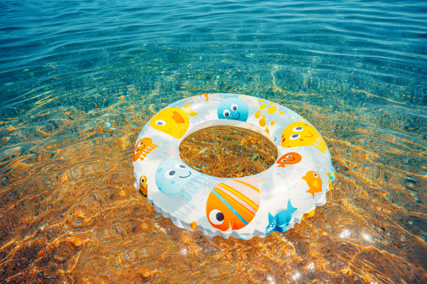 孩子们在海水中漂浮。海滩上的游泳圈图片 孩子们在海水中漂浮。海滩上的游泳圈图片下载