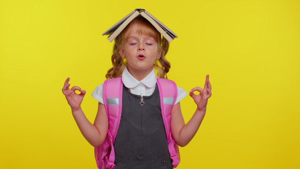 十几岁的女孩穿着校服,把书放在头上,冥想,放松,集中思想图片 十几岁的女孩穿着校服,把书放在头上,冥想,放松,集中思想图片下载