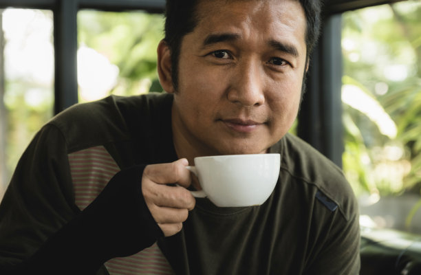 亚洲中年男子在咖啡馆喝咖啡的肖像图片 亚洲中年男子在咖啡馆喝咖啡的肖像图片下载