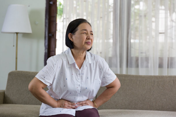 亚洲老妇人坐在家里,肚子疼。退休、隔离和保健的概念图片 亚洲老妇人坐在家里,肚子疼。退休、隔离和保健的概念图片下载