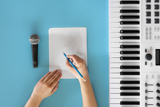 蓝色背景上的琴键、麦克风和白纸。图片 蓝色背景上的琴键、麦克风和白纸。图片下载