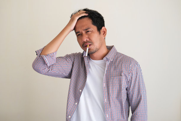 一名男子吸烟并表现出紧张的表情图片 一名男子吸烟并表现出紧张的表情图片下载