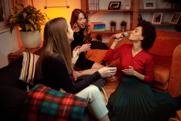 一个非洲女人坐在家里,在卡拉ok派对上唱歌。图片 一个非洲女人坐在家里,在卡拉ok派对上唱歌。图片下载
