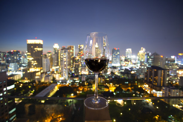 一杯酒,映着城市夜景,模糊了城市天际线的灯光。图片 一杯酒,映着城市夜景,模糊了城市天际线的灯光。图片下载