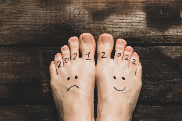 2021年和2022年悲伤和快乐的笑脸画在女孩的腿上,在房子的木地板上,2022年成功,喜悦图片 2021年和2022年悲伤和快乐的笑脸画在女孩的腿上,在房子的木地板上,2022年成功,喜悦图片下载