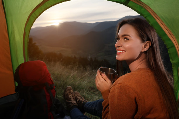 一个年轻女人带着酒在山里的露营帐篷里图片 一个年轻女人带着酒在山里的露营帐篷里图片下载