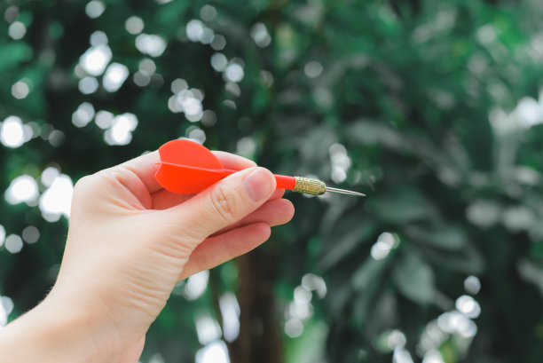 女性手握红镖与散景模糊的背景图片 女性手握红镖与散景模糊的背景图片下载