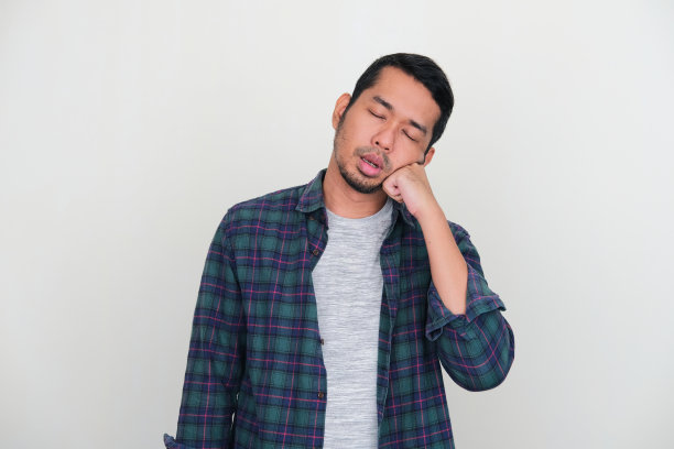 亚洲成年男子因为疲劳而站着睡觉图片 亚洲成年男子因为疲劳而站着睡觉图片下载