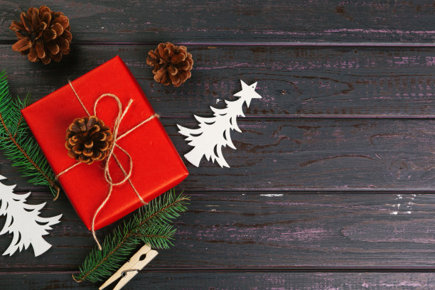 圣诞组成。圣诞礼物,针织毯子,松果,冷杉树枝在木制背景。图片 圣诞组成。圣诞礼物,针织毯子,松果,冷杉树枝在木制背景。图片下载