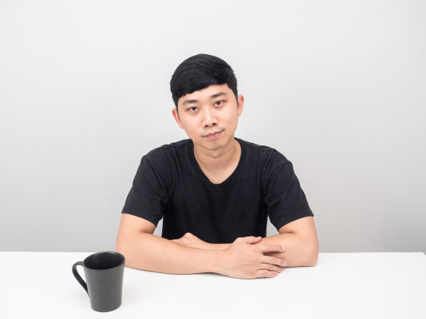 帅哥端着咖啡杯自信地坐在桌前图片 帅哥端着咖啡杯自信地坐在桌前图片下载