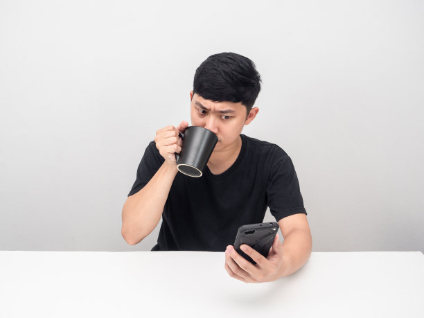 男子喝咖啡杯手势思考,看着手机图片 男子喝咖啡杯手势思考,看着手机图片下载
