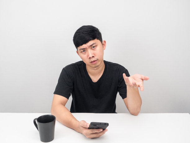 男人拿着手机在桌子上感觉无聊的手势我不知道图片 男人拿着手机在桌子上感觉无聊的手势我不知道图片下载