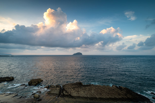 美丽的云,阳光在上面,海洋的倒影,和远处的小岛,从海岸线拍摄,在基隆,台湾。图片 美丽的云,阳光在上面,海洋的倒影,和远处的小岛,从海岸线拍摄,在基隆,台湾。图片下载