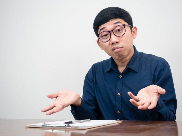 亚洲商人在工作台上对工作感到怀疑和困惑图片 亚洲商人在工作台上对工作感到怀疑和困惑图片下载