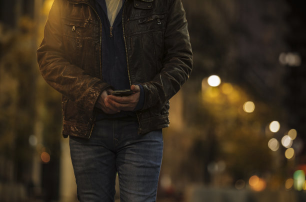 成年男子夜间在街上使用手机的特写镜头图片 成年男子夜间在街上使用手机的特写镜头图片下载