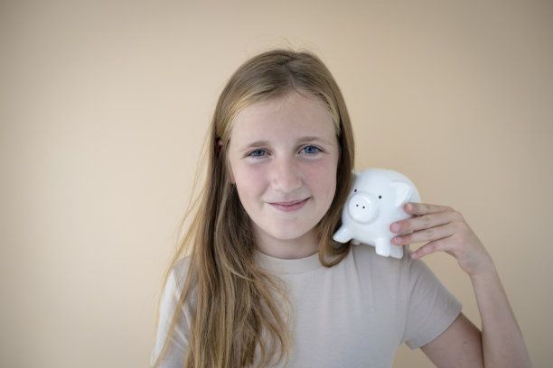 酷的年轻女孩在棕色背景前拿着储蓄罐图片 酷的年轻女孩在棕色背景前拿着储蓄罐图片下载