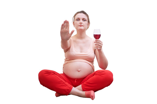 怀孕期间进行锻炼,禁止饮酒。一个女人拿着一杯酒在家里,孤立的白色背景图片 怀孕期间进行锻炼,禁止饮酒。一个女人拿着一杯酒在家里,孤立的白色背景图片下载
