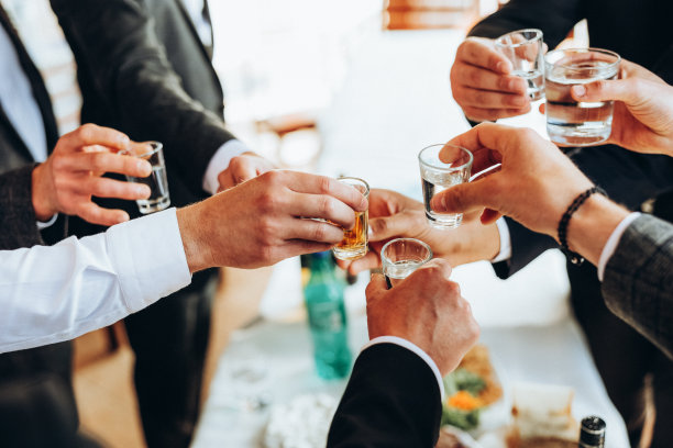 成年男子或女子手持酒杯的裁剪视图。一群年轻人碰杯喝鸡尾酒敬酒。最好的朋友戴着低面罩,滑稽地重聚。图片 成年男子或女子手持酒杯的裁剪视图。一群年轻人碰杯喝鸡尾酒敬酒。最好的朋友戴着低面罩,滑稽地重聚。图片下载