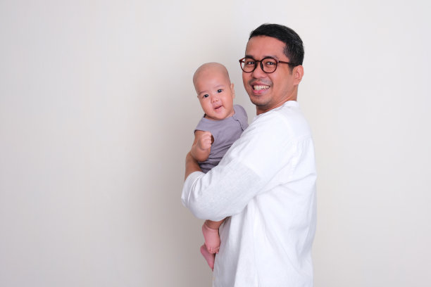 一位父亲抱着他的儿子,脸上洋溢着快乐的表情图片 一位父亲抱着他的儿子,脸上洋溢着快乐的表情图片下载