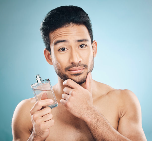 肖像,化妆品和男人与古龙水,美容或自我护理的蓝色工作室背景。脸部,男性或模特与健康,奢侈品或香水与护肤品,香水瓶或修饰图片 肖像,化妆品和男人与古龙水,美容或自我护理的蓝色工作室背景。脸部,男性或模特与健康,奢侈品或香水与护肤品,香水瓶或修饰图片下载