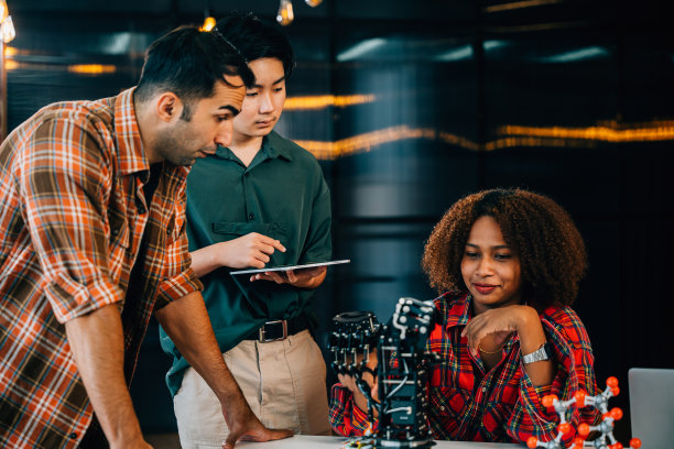 在教室里,学生和老师在机械臂上学习。在教育中培养创新、团队合作和解决问题的能力。机器人的手。创新与科技理念图片 在教室里,学生和老师在机械臂上学习。在教育中培养创新、团队合作和解决问题的能力。机器人的手。创新与科技理念图片下载