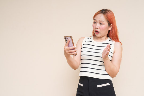 美丽的亚洲女人的肖像看起来震惊和惊讶使用手机图片 美丽的亚洲女人的肖像看起来震惊和惊讶使用手机图片下载