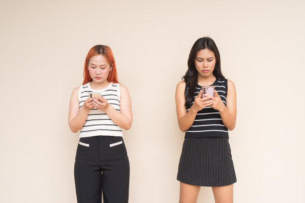 两个美女在户外用手机发短信的画像图片 两个美女在户外用手机发短信的画像图片下载