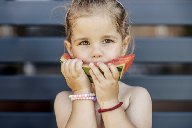 可爱的小女孩在外面吃西瓜的照片。图片 可爱的小女孩在外面吃西瓜的照片。图片下载