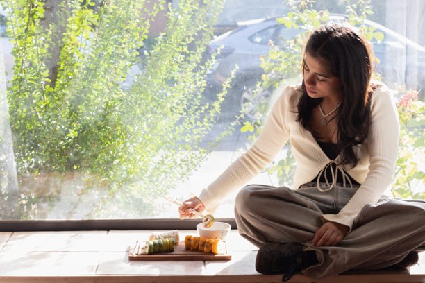 逆光下的小女孩吃寿司的照片图片 逆光下的小女孩吃寿司的照片图片下载