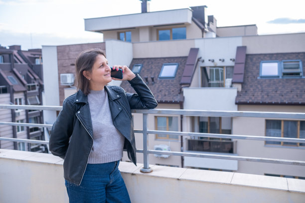 女人在阳台上边打电话边欣赏城市景观图片 女人在阳台上边打电话边欣赏城市景观图片下载