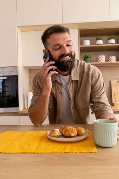 开心打电话的男人在厨房柜台边图片 开心打电话的男人在厨房柜台边图片下载