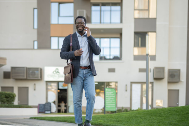 微笑的男人走在上班的路上,边打电话边聊天图片 微笑的男人走在上班的路上,边打电话边聊天图片下载