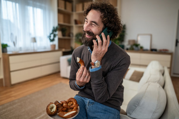 男人在家一边吃椒盐卷饼一边打电话图片 男人在家一边吃椒盐卷饼一边打电话图片下载