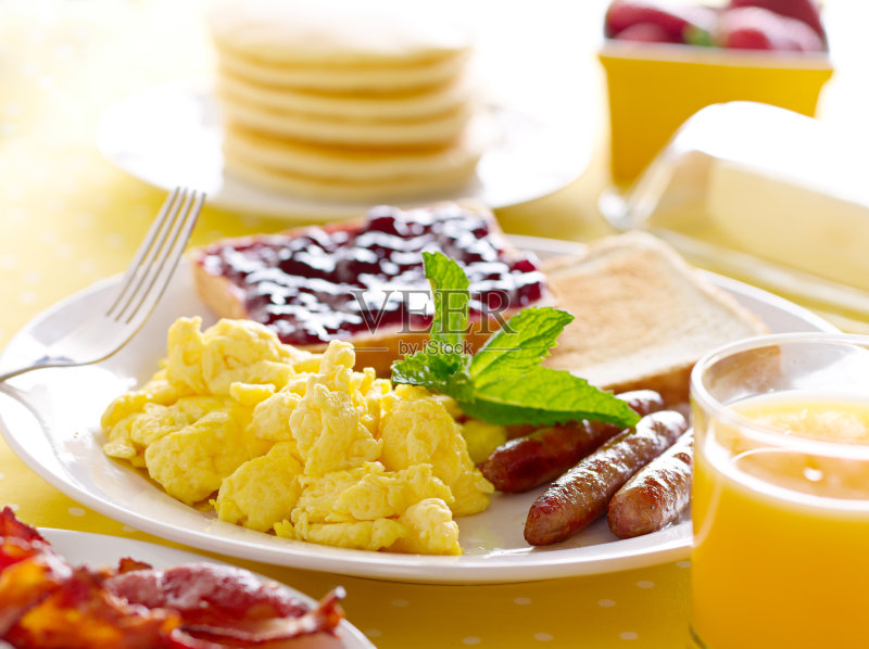 有炒蛋、香肠和烤面包的早餐盘正版图片素材