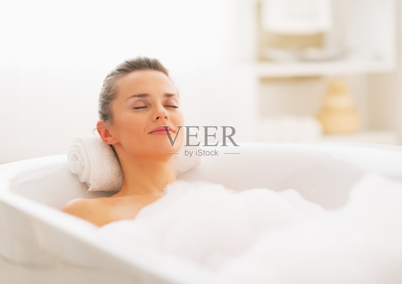 一个悠闲的年轻女子泡在泡泡浴中的肖像正版图片素材